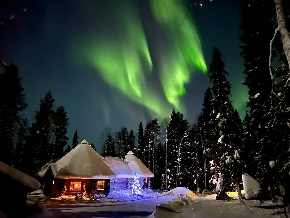 Northern lights above a timber cabin at night