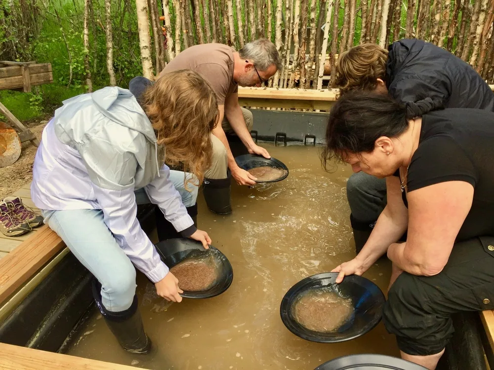 Guests panning for gold at a wooden trough
