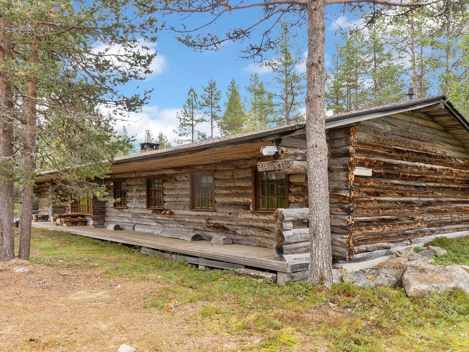 The long timber flank of Raahenmaja among summer pines