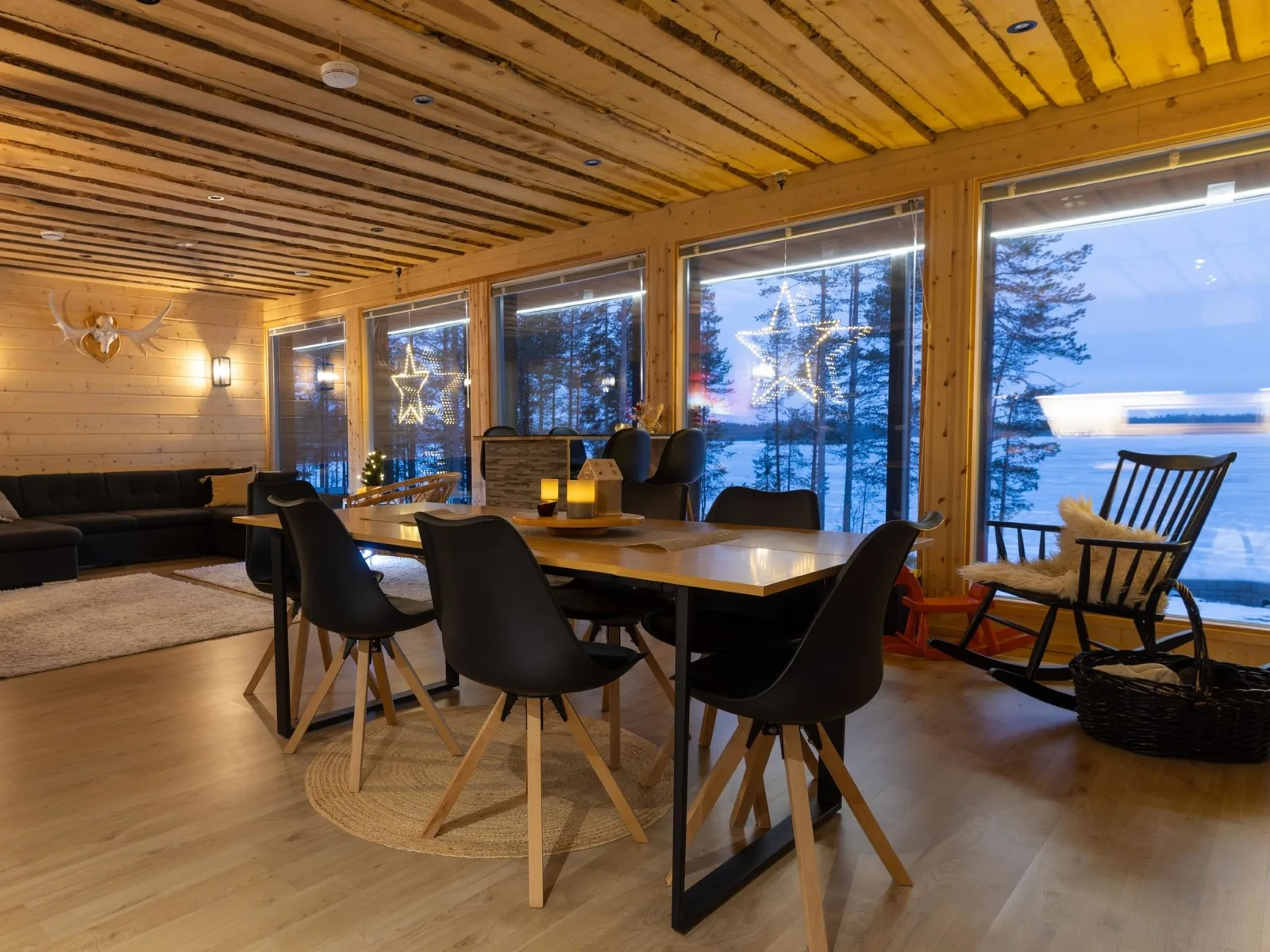 The glazed dining room at Villa Kesäranta at blue hour, with the lake beyond