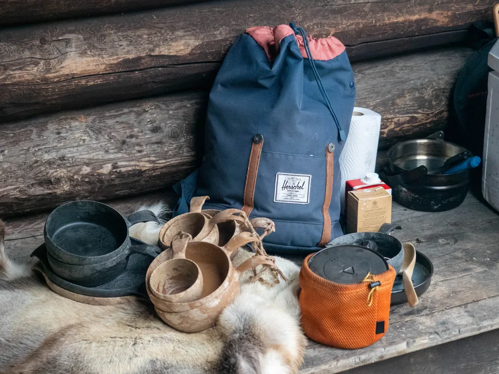 Two wooden kuksa cups resting on a reindeer hide