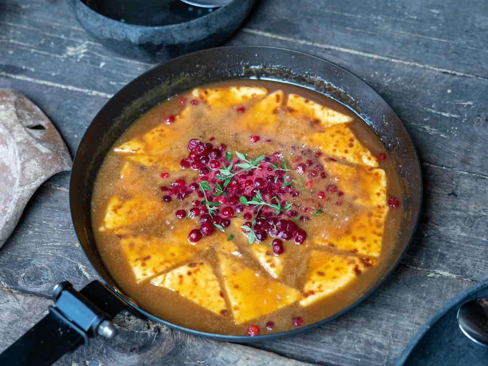 Lingonberries warming in a black iron pan outdoors